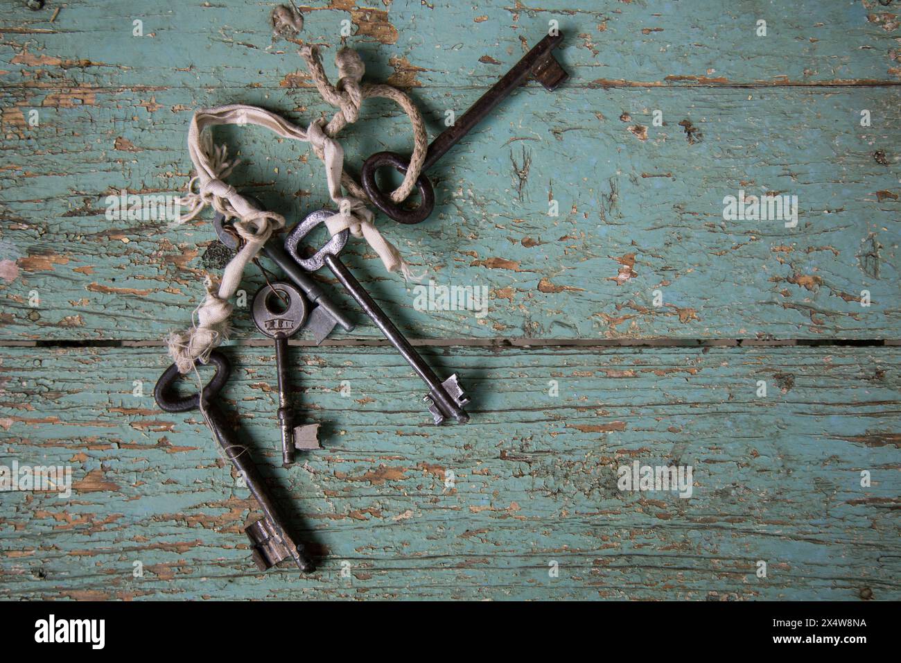 Stringed Keys Collection of antique iron keys tied with string on distressed ...