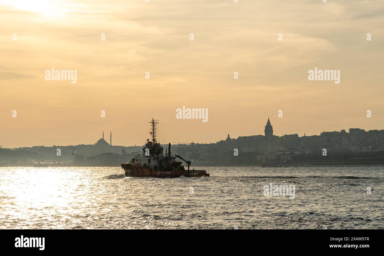 Serene sunset over a calm sea with a silhouette of a boat, creating a tranquil and picturesque scene. Istanbul,Turkey Stock Photo