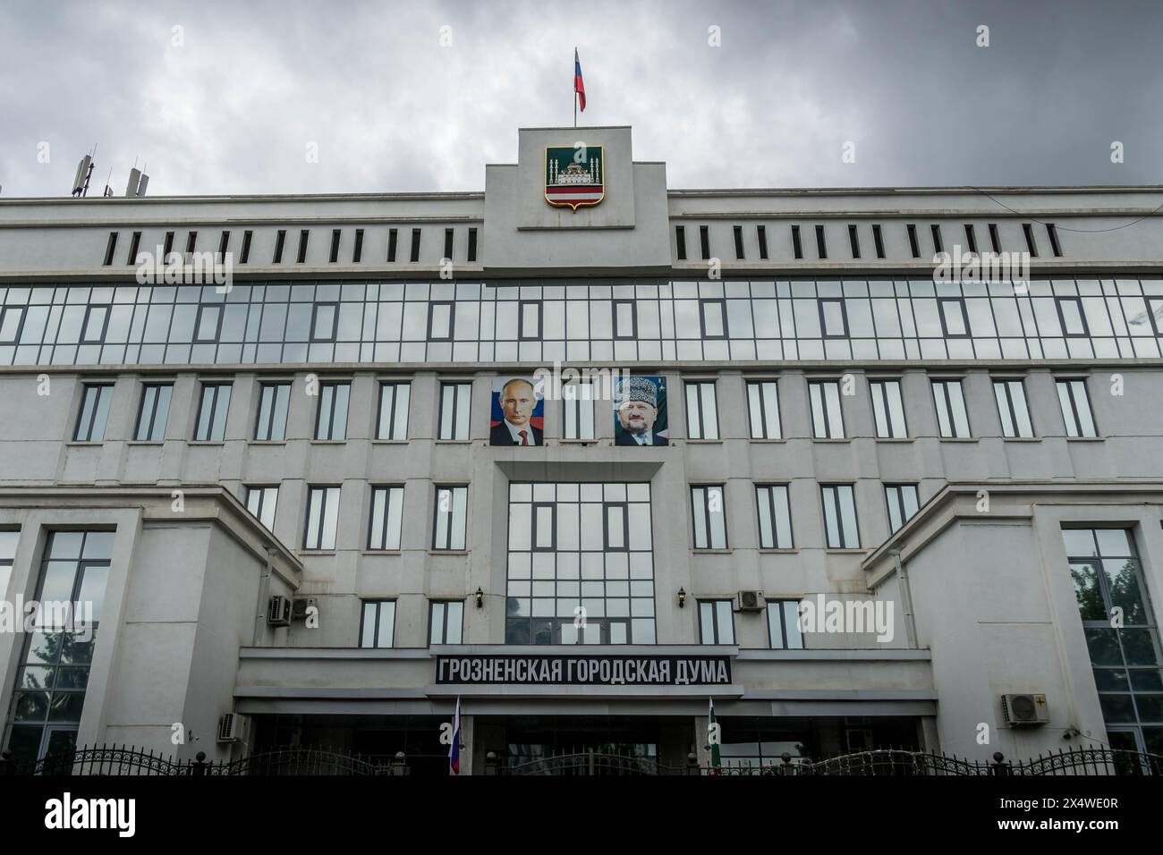 The city administration in Grozny, Republic of Chechnya, with the flag and coat of arms, and portraits of Vladimir Putin and Akhmad-Khadzhi Kadyrov. Stock Photo