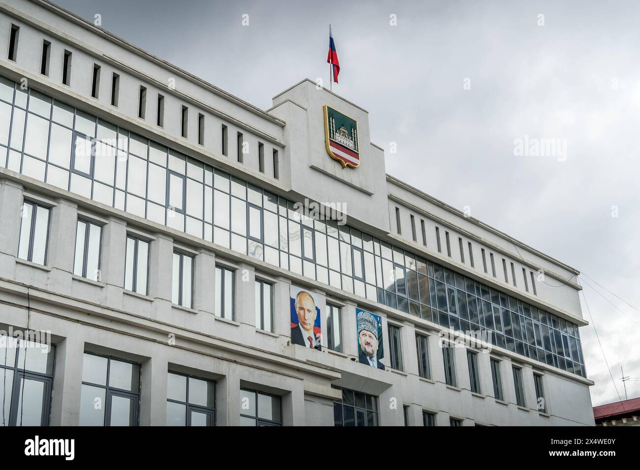 The city administration in Grozny, Republic of Chechnya, with the flag and coat of arms, and portraits of Vladimir Putin and Akhmad-Khadzhi Kadyrov. Stock Photo