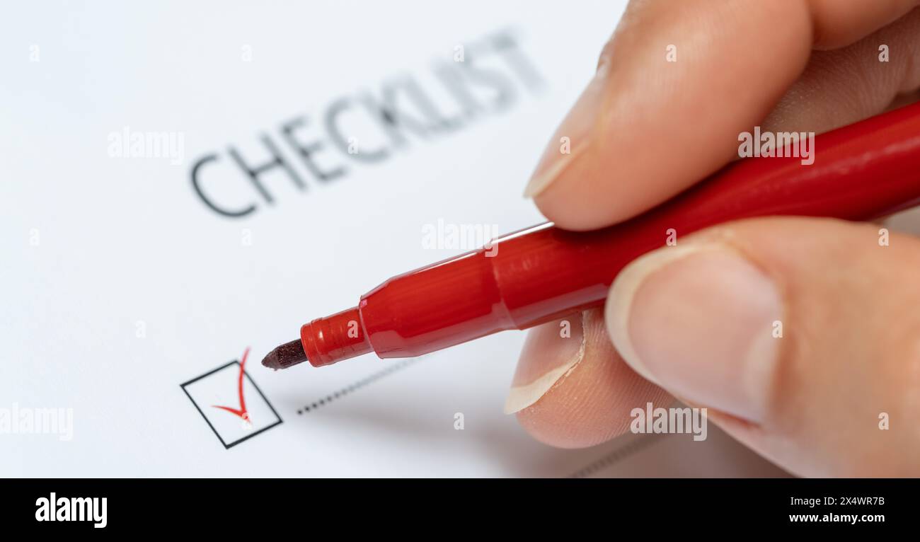 red marker ticking off a checkbox on a checklist Stock Photo