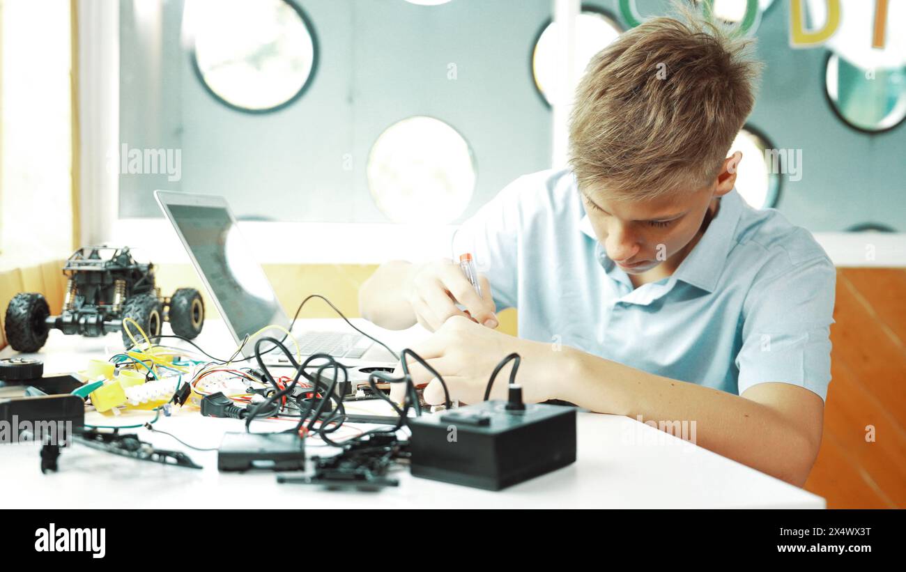 Caucasian boy fixing main board while study construction by using ...