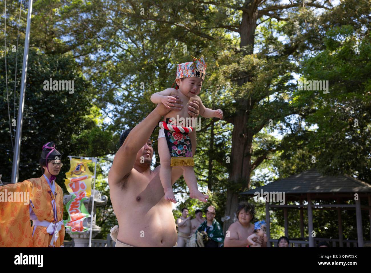 Yokohama, Japan. 05th May, 2024. Crying baby is being lifted in the air by a sumo wrestler during Nakizumo inside a Shinto shrine. Nakizumo, in English called 'Crying Baby Festival' is done in the name of blessing the baby as “naku ko wa sodatsu” which translates to “crying babies grow”, meaning babies who cry would grow up strong and healthy. Nakizumo also serves to drive away evil spirits and is performed inside Shinto shrines. Credit: SOPA Images Limited/Alamy Live News Stock Photo