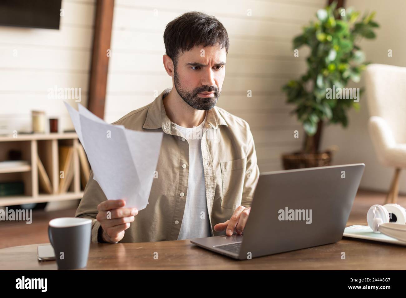 Distressed Man Working on Laptop at Table Stock Photo