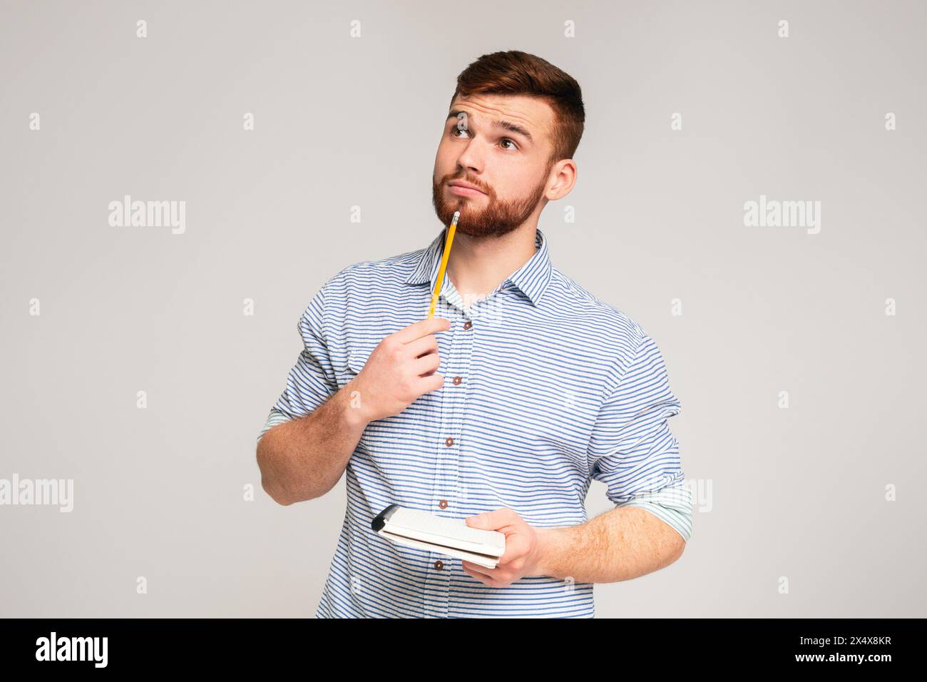 Young man thinking about checklist what to do Stock Photo