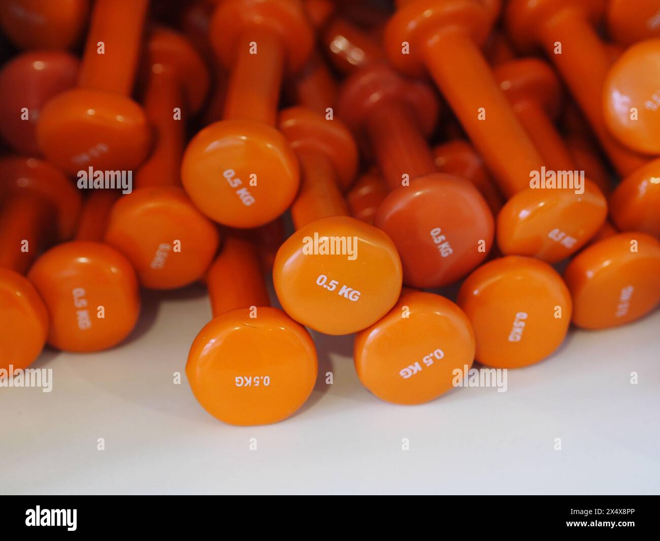 A stack of orange dumbbells with the numbers 0-5 on them Stock Photo