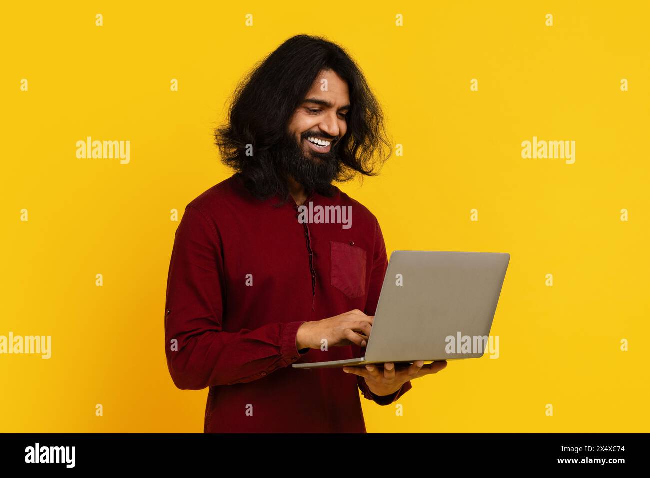 Man With Long Hair and Beard Using a Laptop Stock Photo