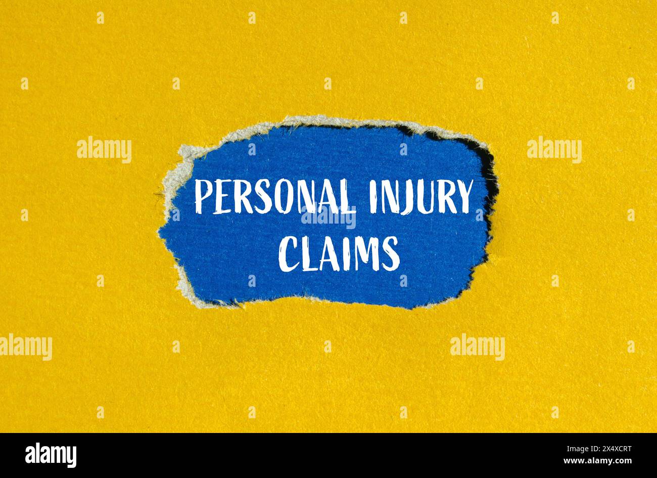 Personal injury claims written on ripped yellow paper with blue background. Conceptual personal injury claims symbol. Copy space. Stock Photo
