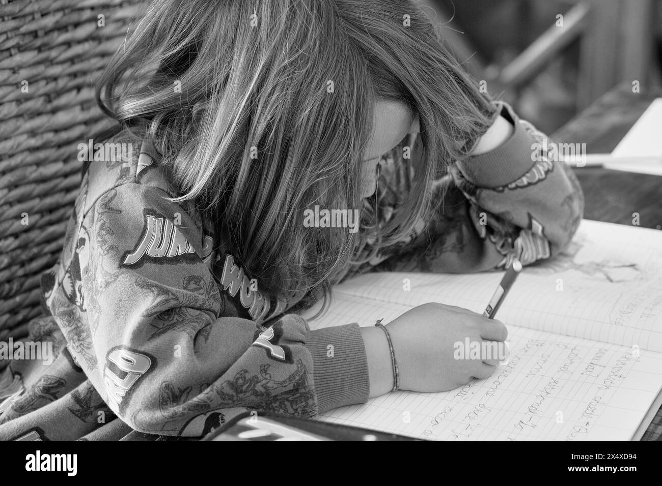 Italy, Sicily; 8 years old male child doing his homework on a table at home Stock Photo