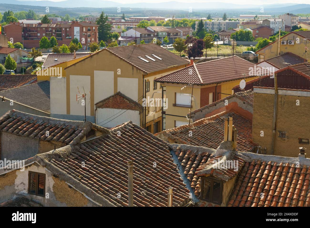 A sprawling cityscape as seen from the rooftop of a building, showcasing urban architecture, roads, cars, and people going about their daily activitie Stock Photo