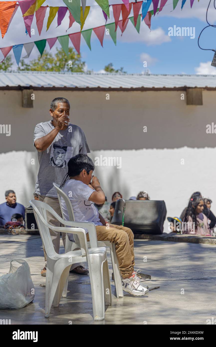 Jujuy, Argentina - January 25th 2024: Godfather and godson toasting at a traditional party in Humahuaca. Stock Photo