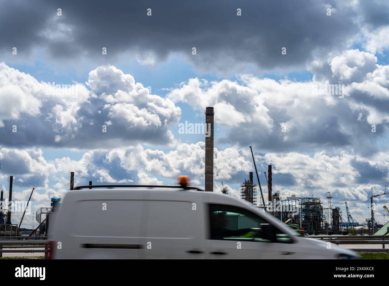 White van passing in front of an oil refinery Stock Photo