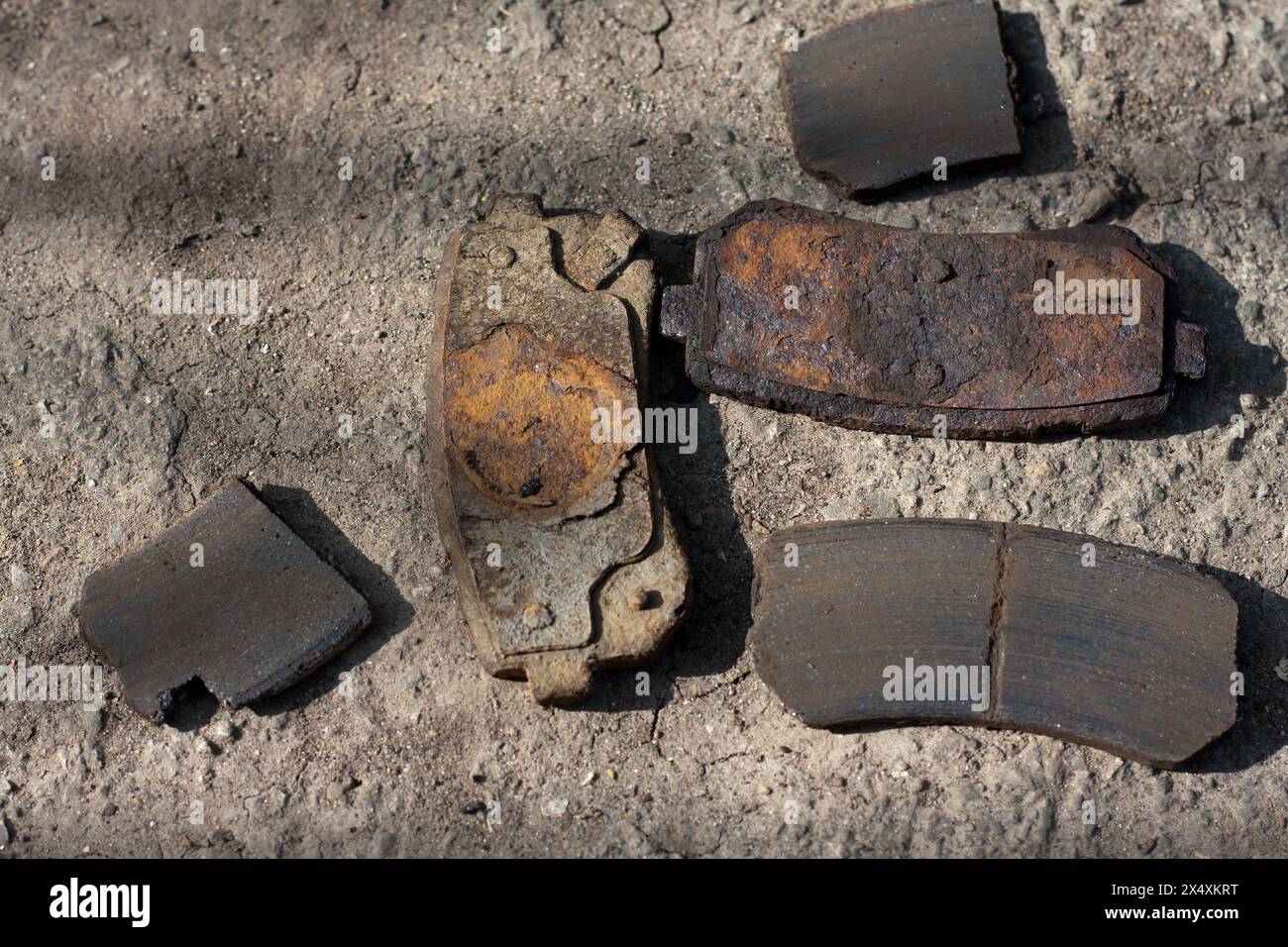 Close up of uneven car brake pad wear. Old rusty car brake system parts