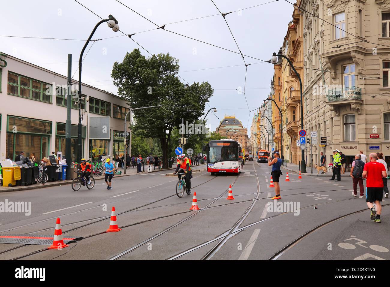 PRAGUE, CZECH REPUBLIC - MAY 5, 2024: The very last runner in Prague Marathon is accompanied by volunteers in one of biggest marathon races in Europe. Stock Photo