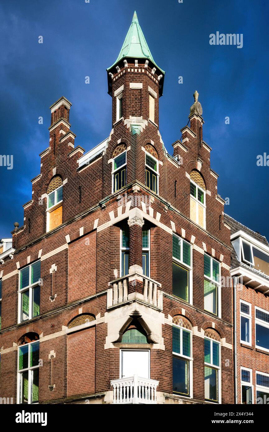 historic ornate brick buildings in the city centre of utrecht in the netherlands against a cloudy dark blue sky Stock Photo