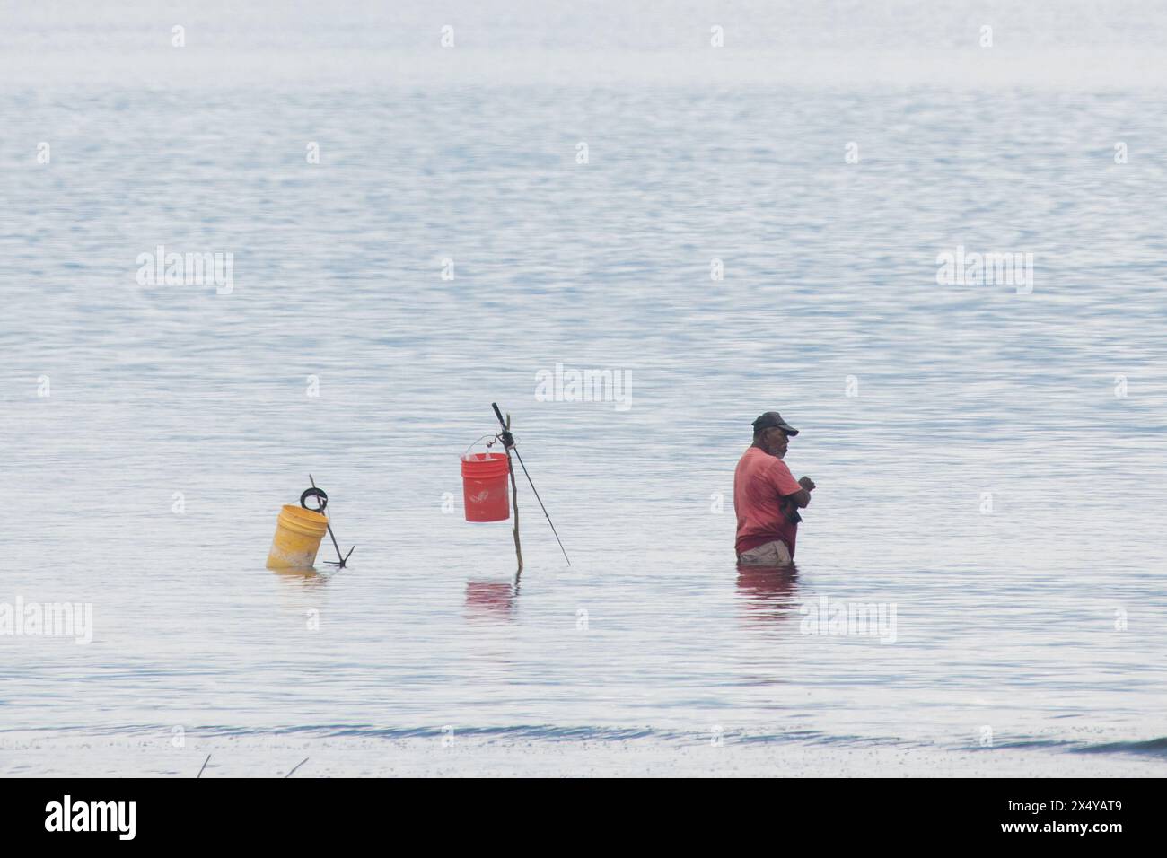 Subsistence or artisanal fishing is small scale marine harvest by individual fishermen, like this local man in Costa Rica catching fish in Golfo Dulce. Stock Photo