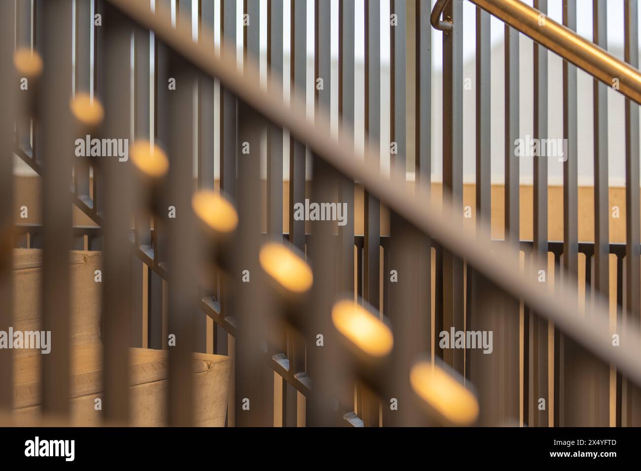 Close-up photo of a modern gray metal railing and concrete stair case between floors. Stock Photo