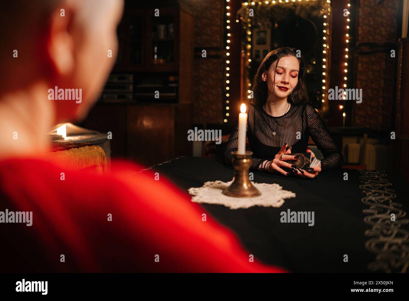 View from shoulder of enigmatic fortune teller reading tarot cards to