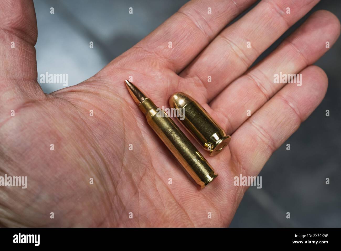 Rifle and pistol cartridge in a man's hand closeup Stock Photo Alamy