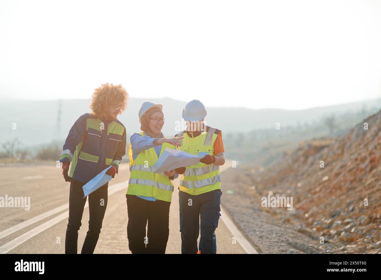 A team of engineers and workers oversees a wind turbine project at a ...