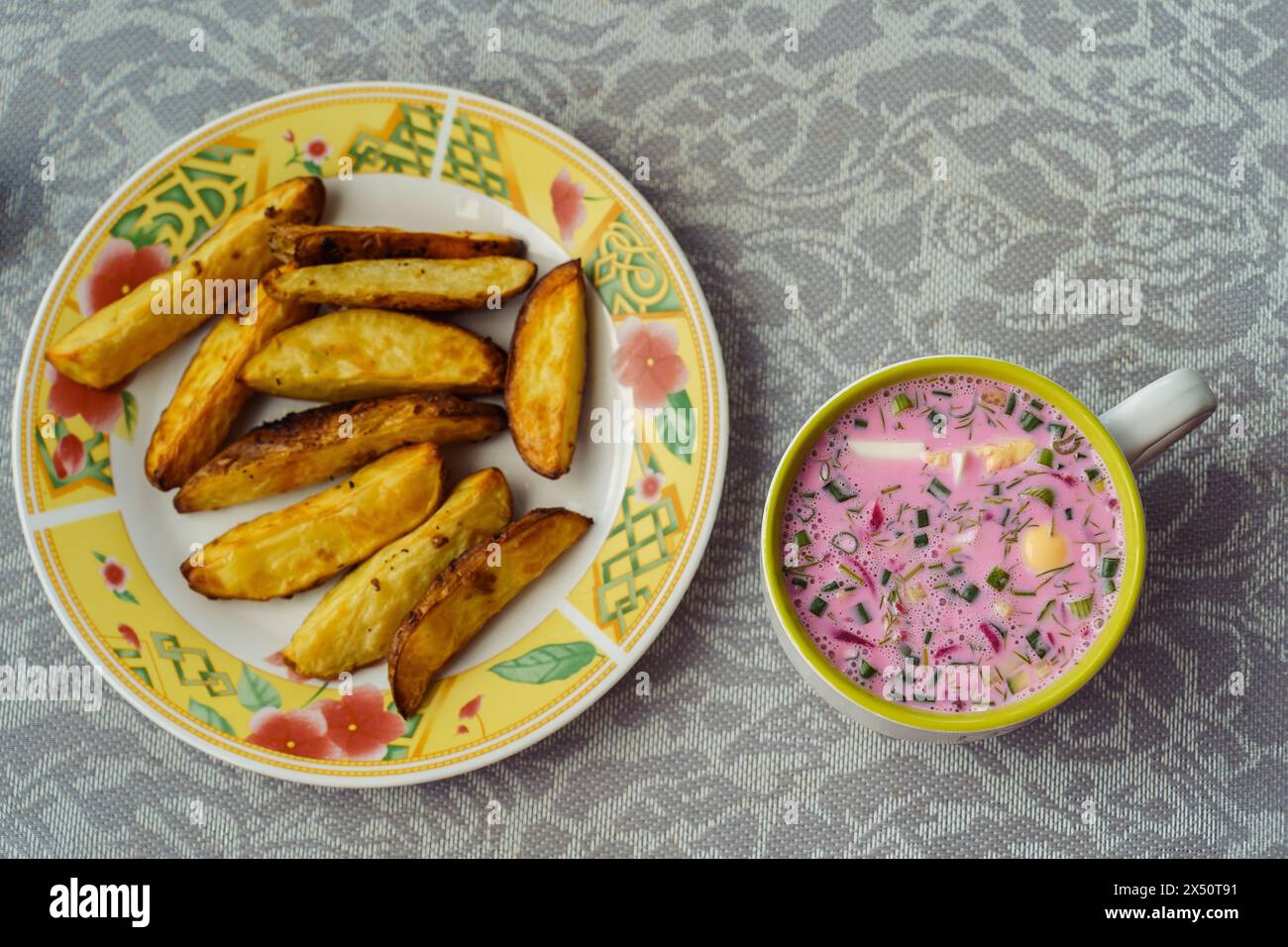 A bowl of popular Lithuanian cold beetroot soup Saltibarsciai with baked potato wedges Stock Photo