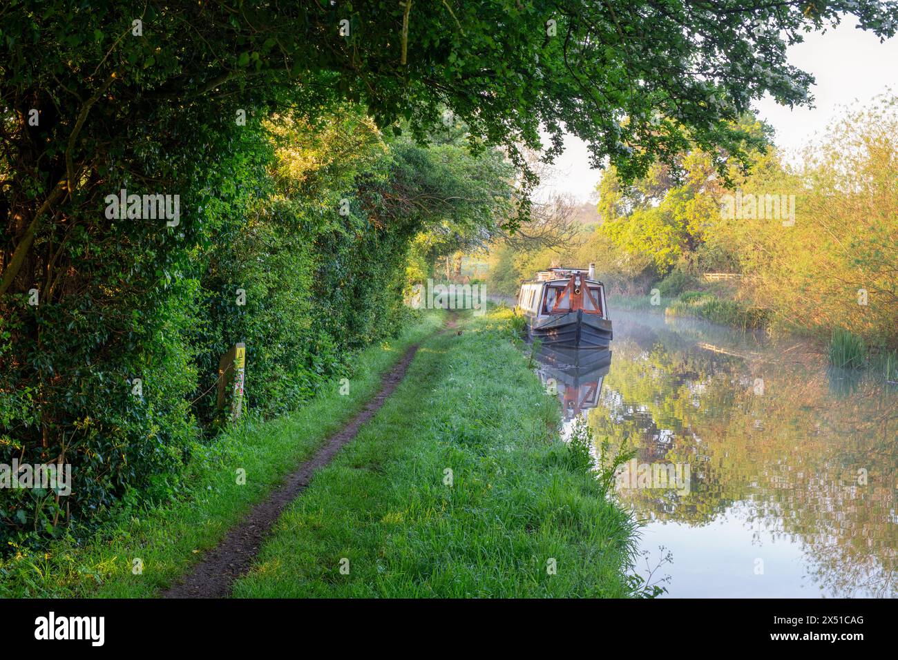 Narrowboat on the Oxford canal in spring at sunrise near Twyford wharf. Kings Sutton, Oxfordshire / Northamptonshire border, England Stock Photo
