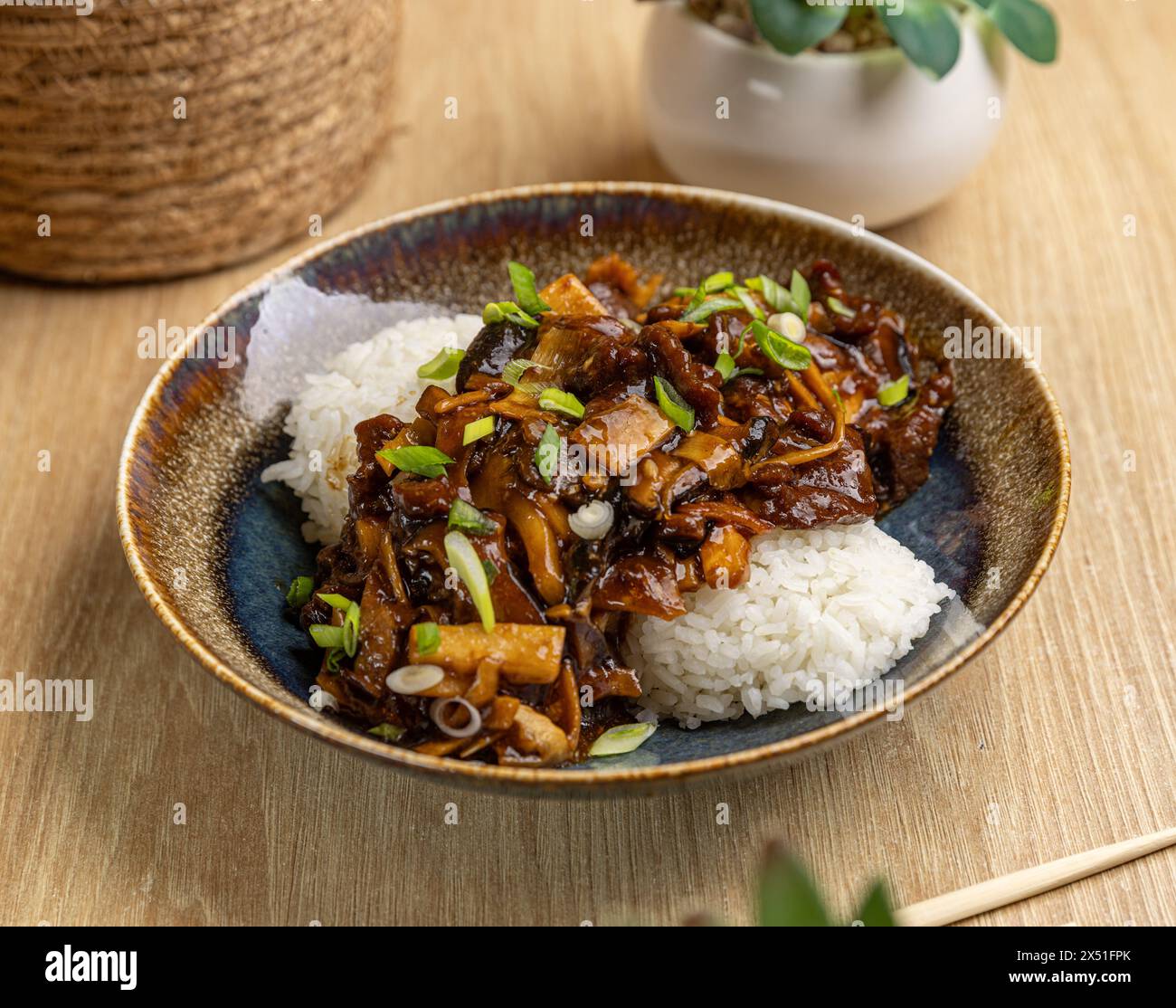 Savory beef stir fry with rice in ceramic bowl Stock Photo