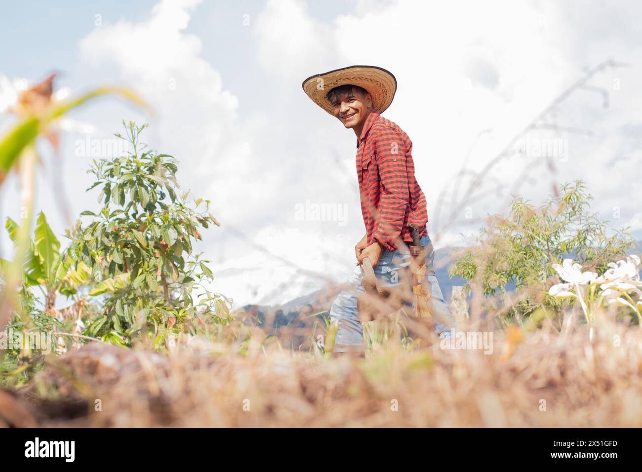 lifestyle: happy young farmer uses hoe on his crop Stock Photo - Alamy