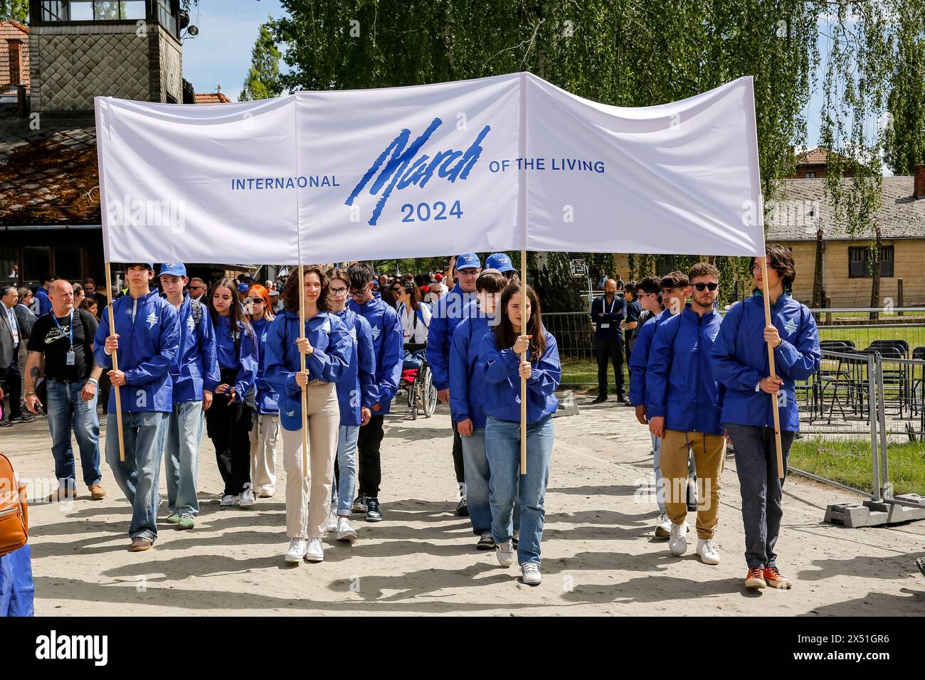 Youth leads the March of the Living 2024 at Auschwitz Camp gate 'Work Makes you Free', with 55 holocaust survivors participating, on May 06, 2024 in O?wi?cim, Poland. Holocaust survivors, and October 7th survivors attend the March of the Living together with a delegation from, among others, the United States, Canada, Italy, United Kingdom. On Holocaust Memorial Day observed in the Jewish calendar (Yom HaShoah), thousands of participants march silently from Auschwitz to Birkenau. The march has an educational and remembrance purpose. This year March was highly politicized due to the Israeli war Stock Photo