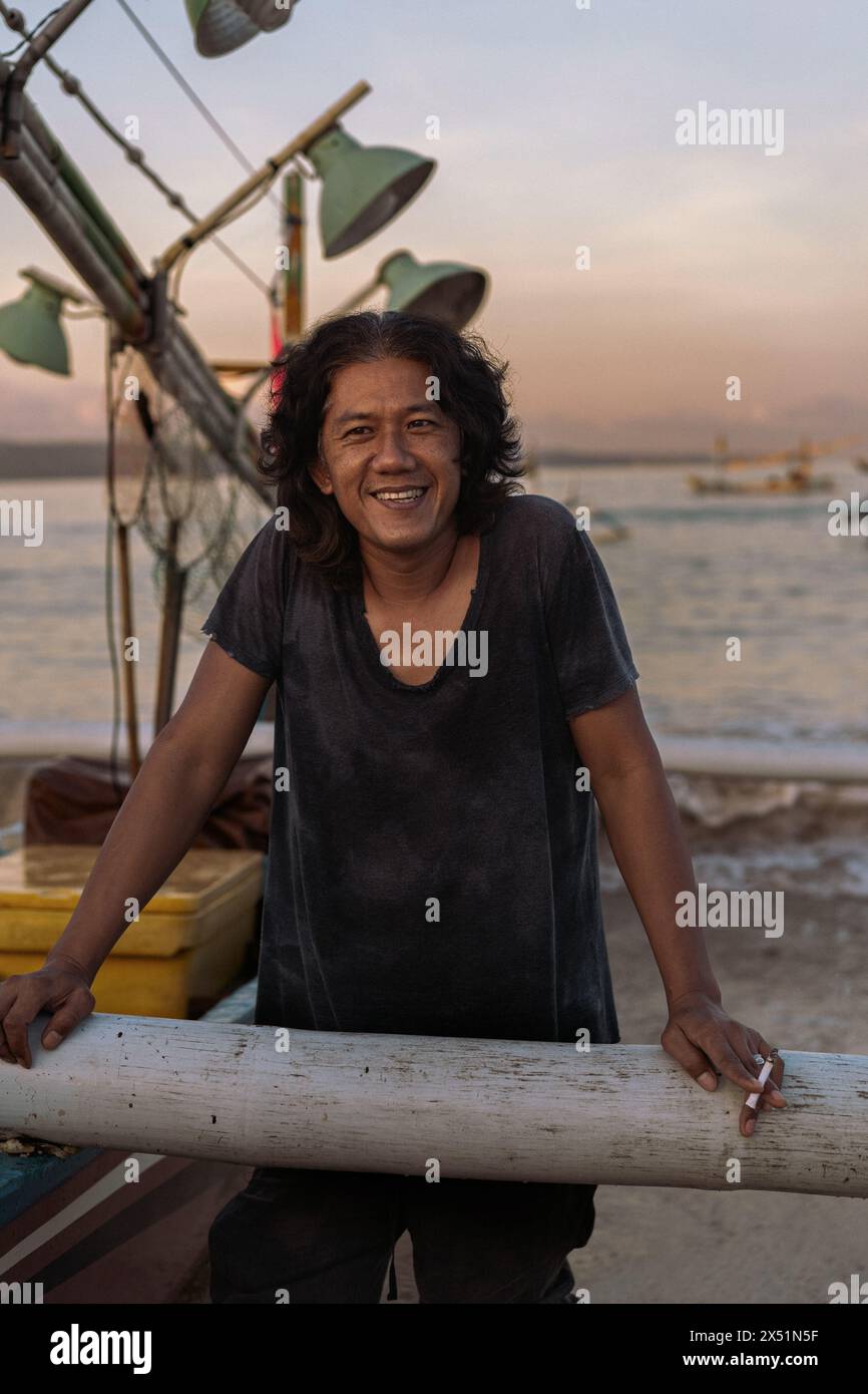 The fisherman near the fishing boat returned from the sea with a Stock Photo