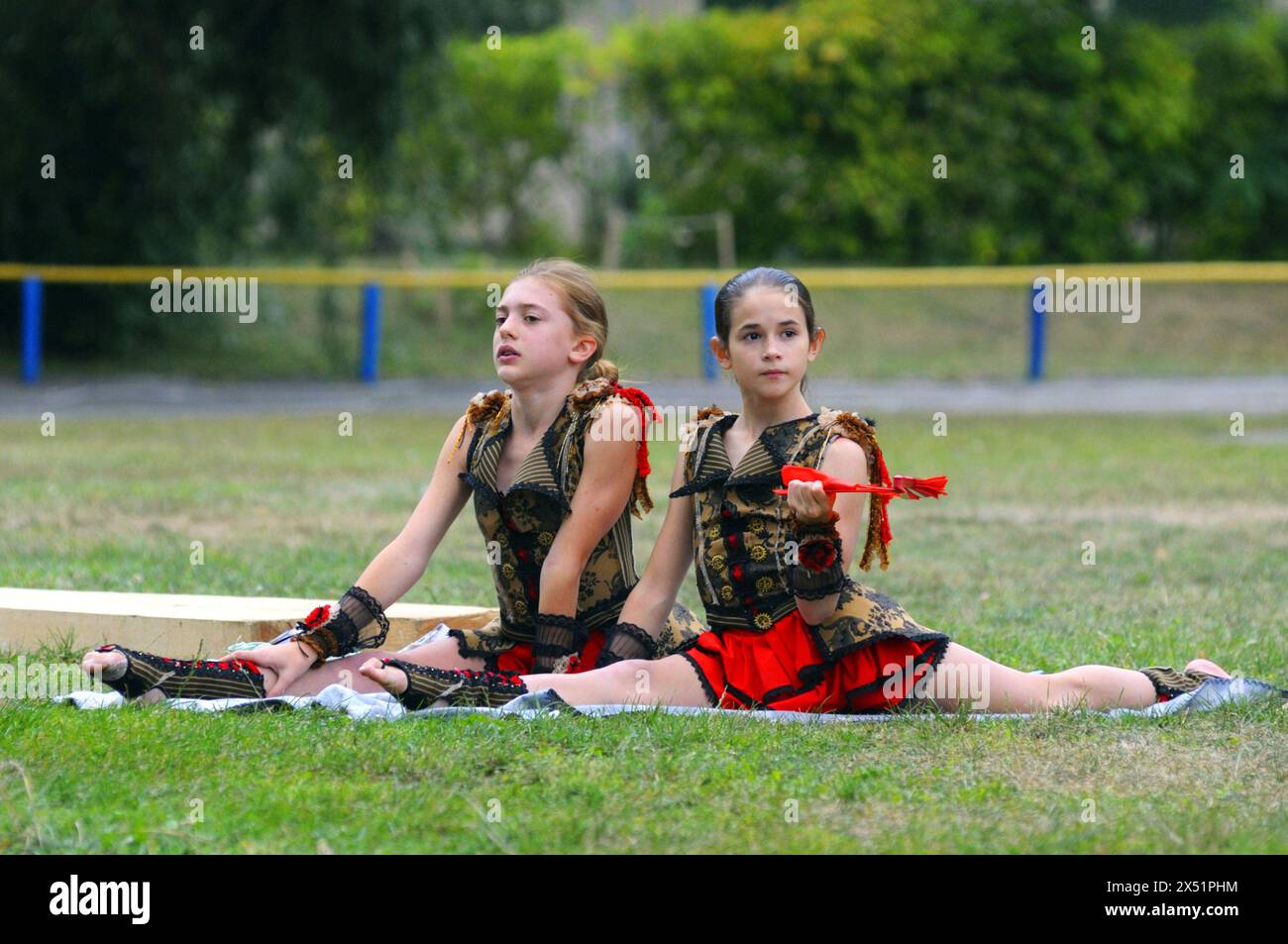 Two little girls artistic gymnastics doing split with a fan, stadium. Opening the University of physical culture and sport. June 20, 2019. Kyiv, Ukrai Stock Photo