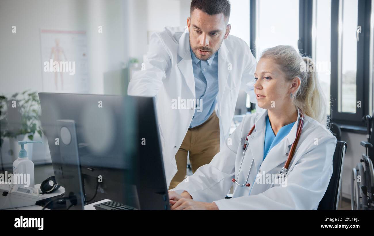 Hospital Medical Doctor's Office: Two Professional Physicians Talking, Solving Problem, Working on Computer. Specialists Discuss Patient Online Treatment, Writing Digital Medicine Prescriptions Stock Photo