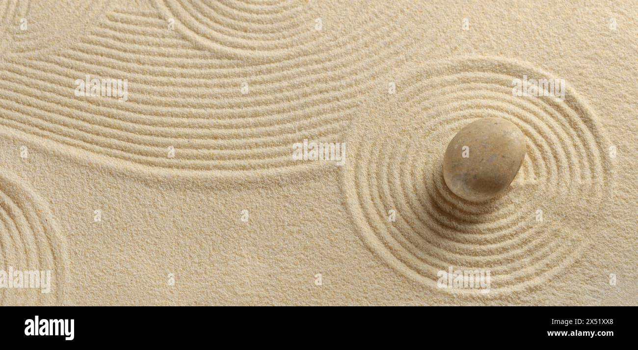 Zen garden with the sand pattern and a single stone Stock Photo