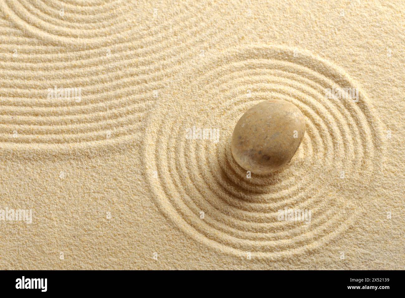 Zen garden with the sand pattern and a single stone Stock Photo