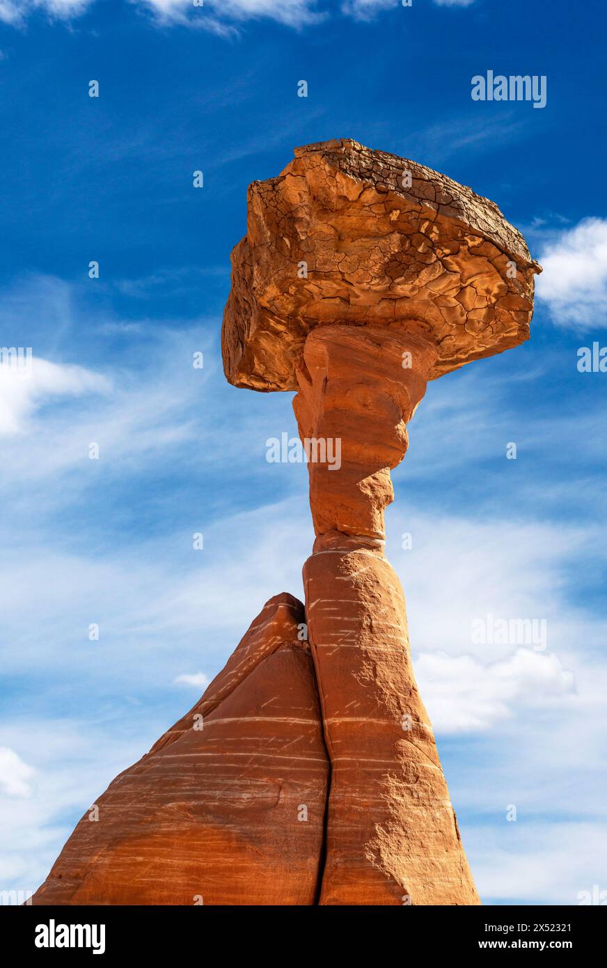 White and red sandstone toadstool hoodoo at Kanab Utah showing highly eroded spires and balanced harder rock on top framed by a blue sky. Stock Photo