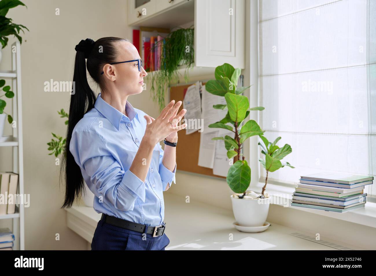Serious thoughtful woman in her 30s looking out the window Stock Photo ...
