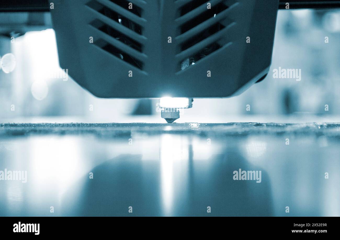 3D printer working close-up. 3D printer prints a model from molten ...