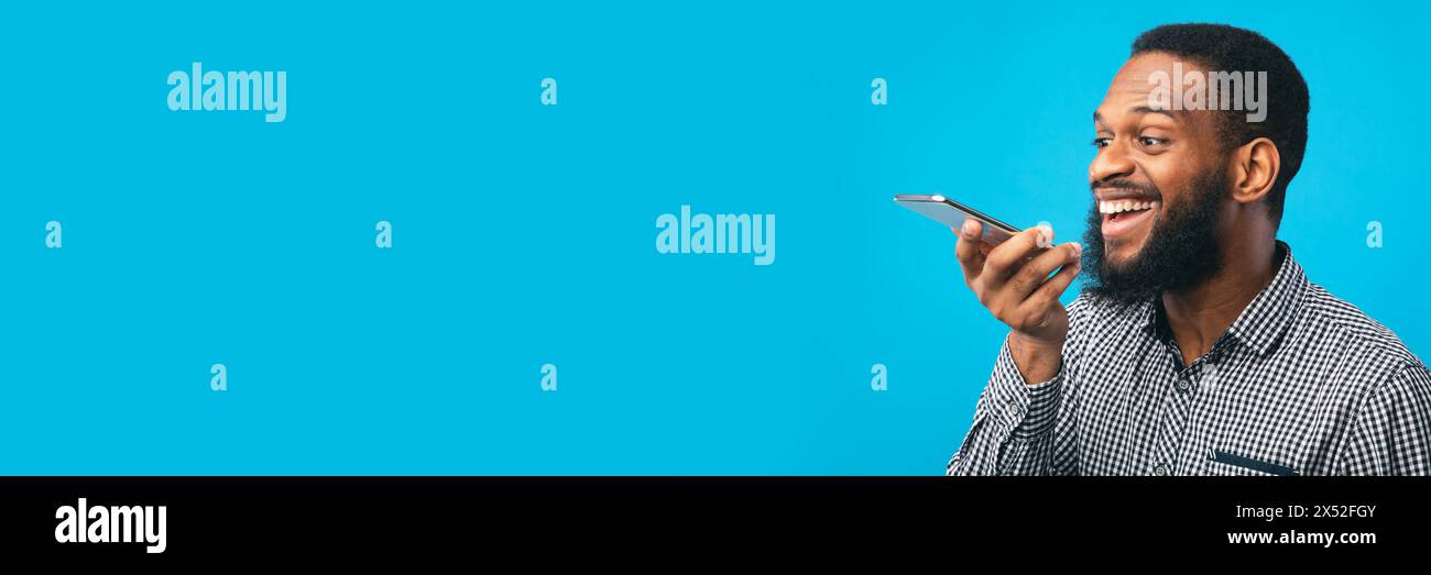Happy black man using voice assistant on smartphone Stock Photo