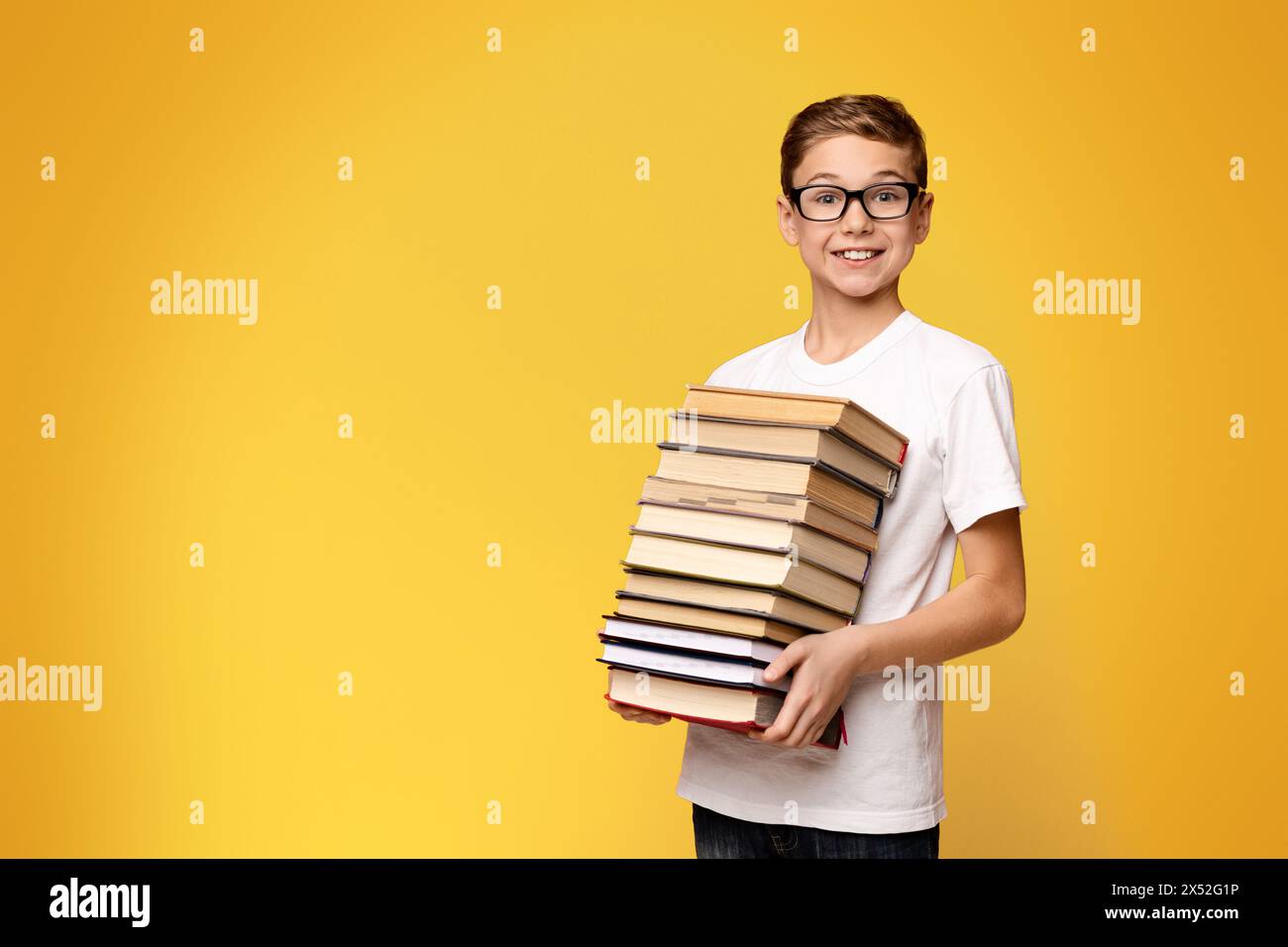 Young Boy Holding Stack of Books Stock Photo - Alamy