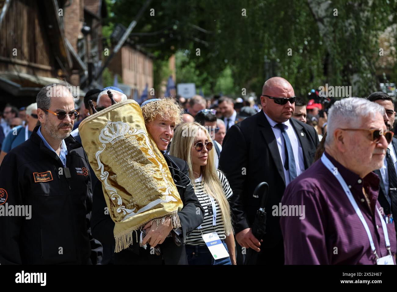 Oswiecim, Poland, May 6, 2024. Participants walk in the March of the Living 2024 at Auschwitz Camp gate 'Work Makes you Free', with 55 holocaust survivors participating. Holocaust survivors, and October 7th survivors attend the March of the Living together with a delegation from, among others, the United States, Canada, Italy, United Kingdom. On Holocaust Memorial Day observed in the Jewish calendar (Yom HaShoah), thousands of participants march silently from Auschwitz to Birkenau. The march has an educational and remembrance purpose. This year March was highly politicized due to the Israeli w Stock Photo