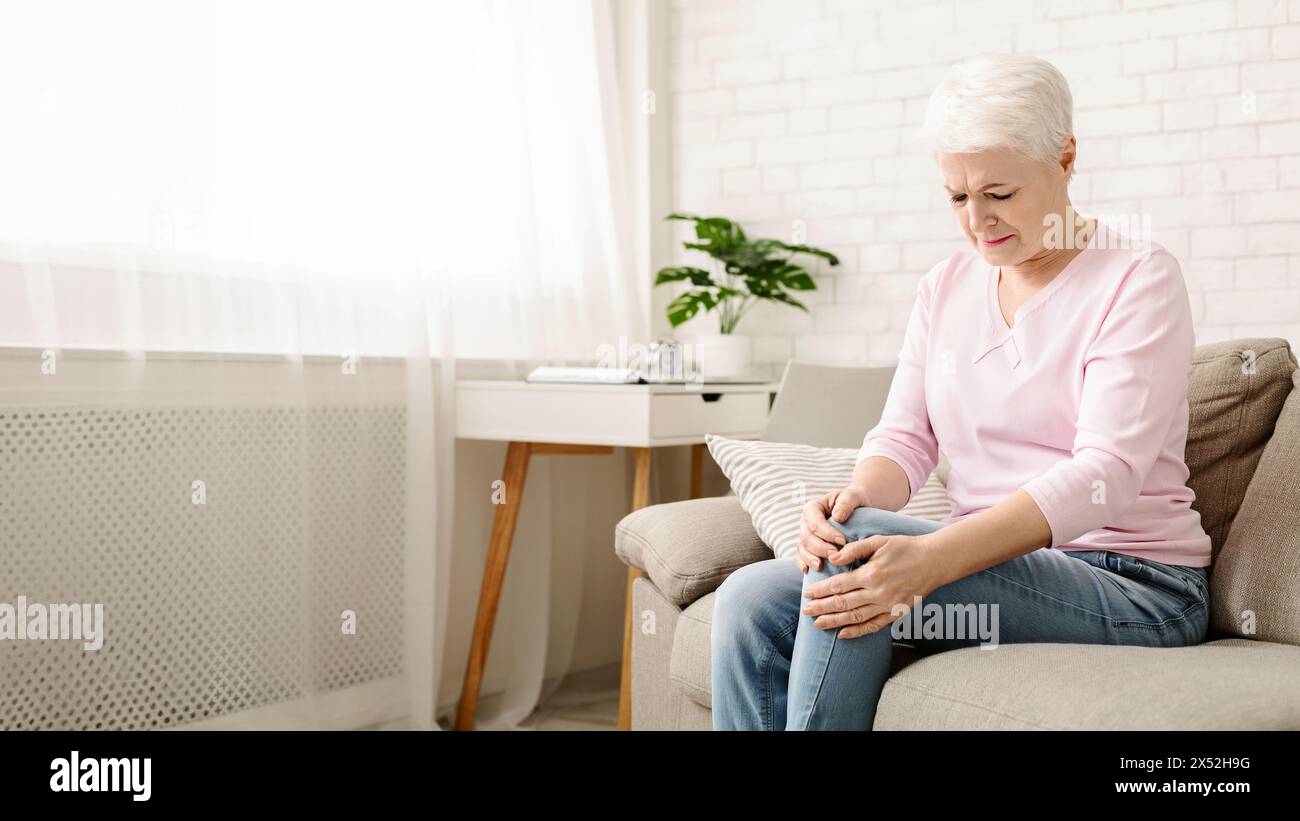 Senior woman suffering from pain in leg, massaging her knee Stock Photo ...