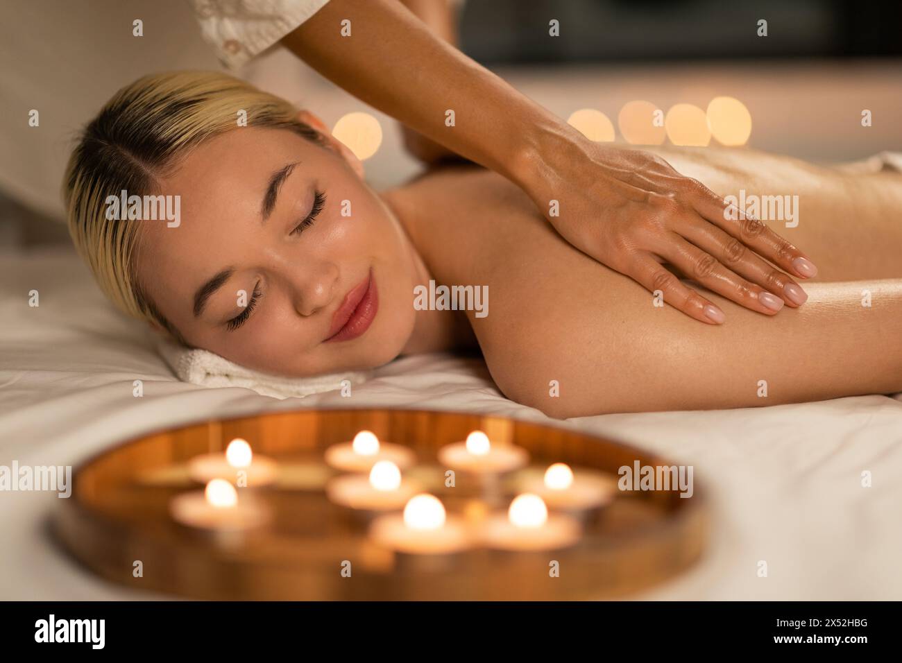 Blonde Woman Experiencing a Calming Spa Massage Stock Photo