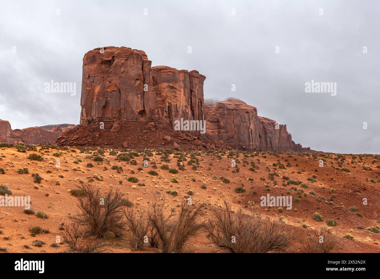 Large mountain along the side of Monument Valley's scenic park during a cloudy day shows the rock patterns, generally made of sandstone, moenkopi and Stock Photo