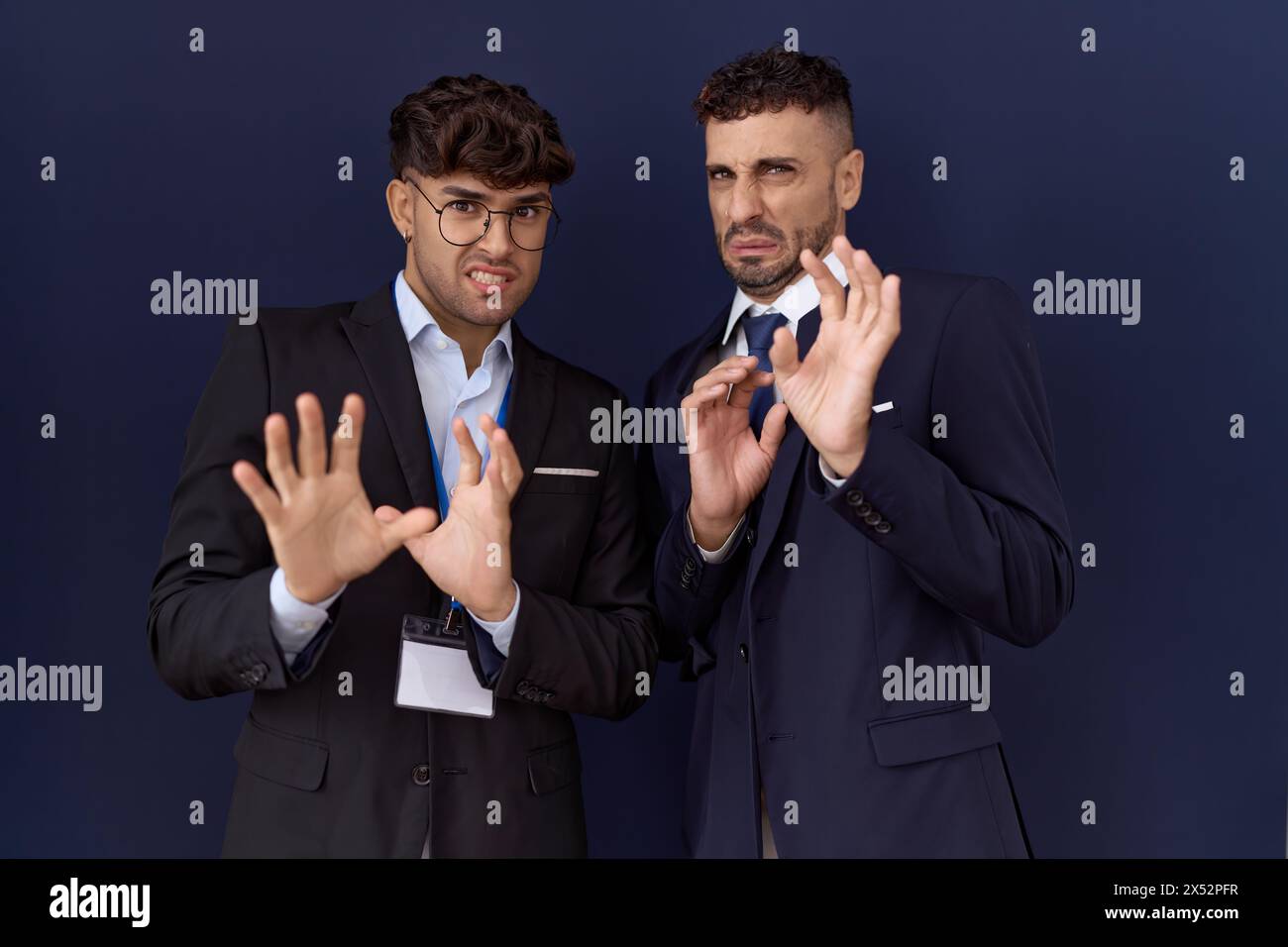 Two hispanic business men wearing business clothes disgusted expression ...