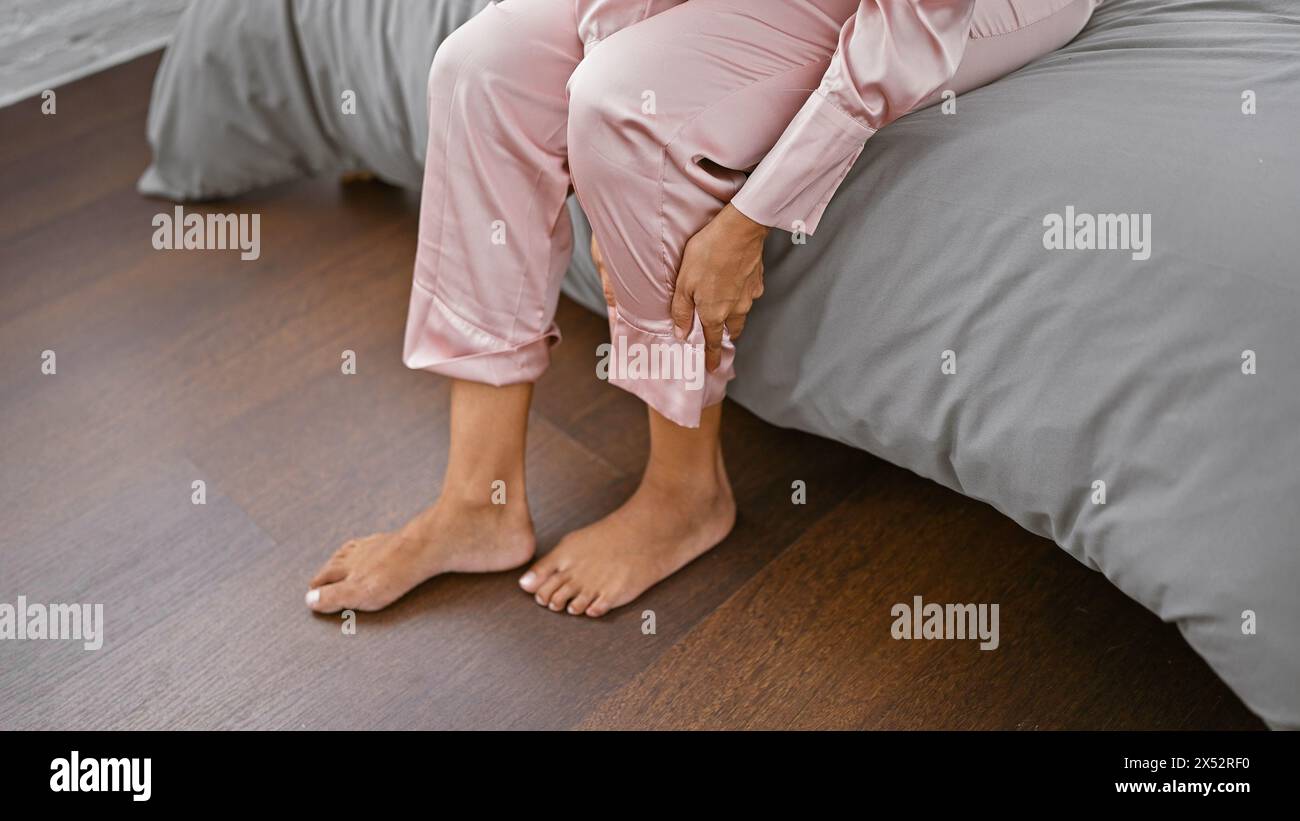 Hispanic woman's hands massaging aching feet while sitting on