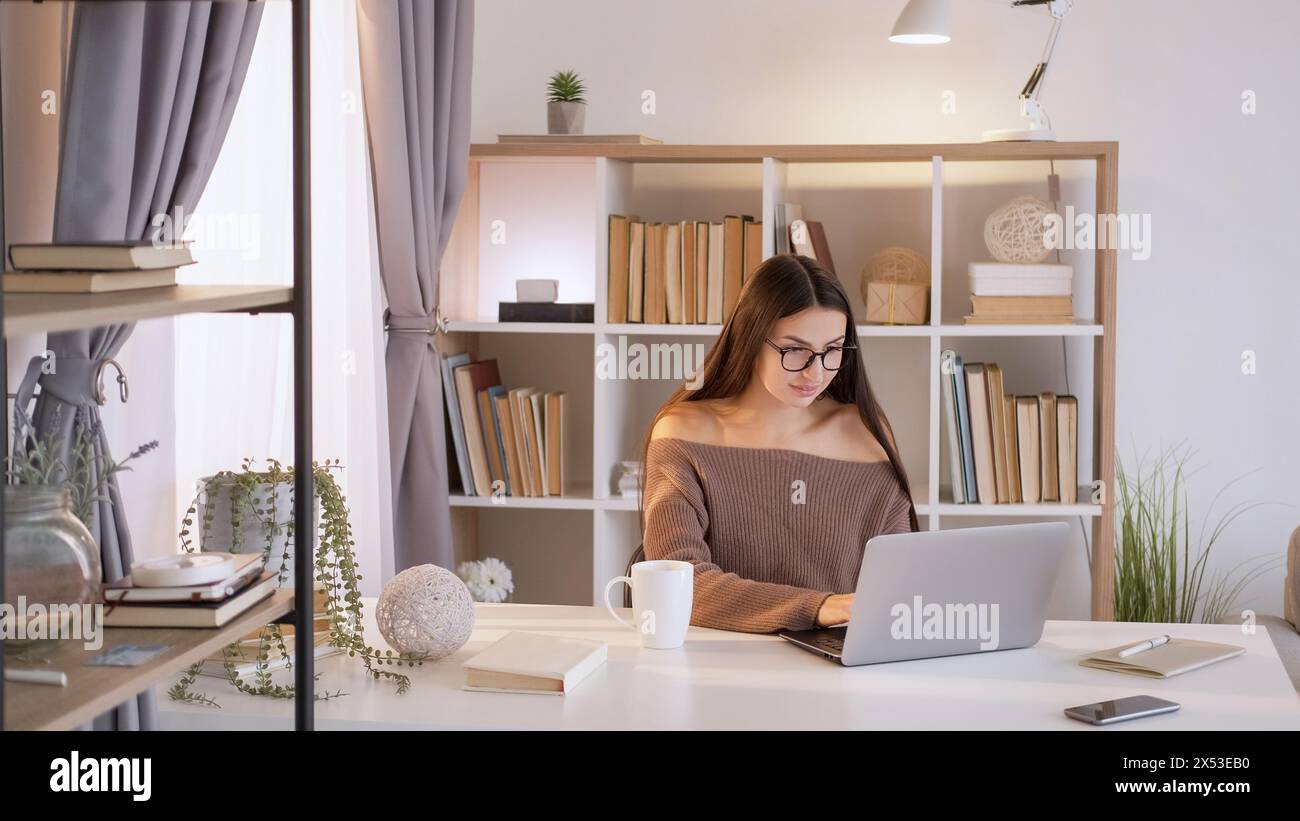 Home education. Computer homework. Concentrated smart woman typing at ...