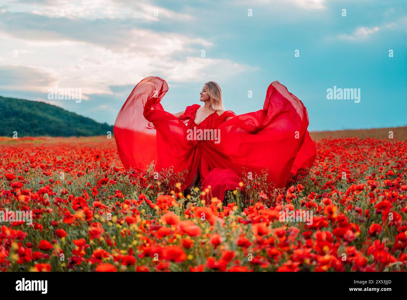 Woman poppy field red dress. Happy woman in a long red dress in a ...