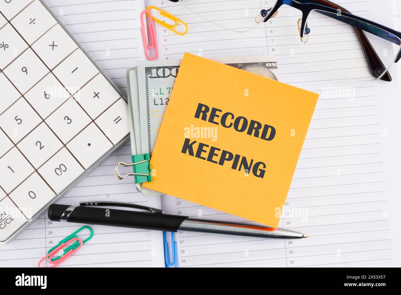 Record keeping text concept on a yellow sticker with money on a business notebook Stock Photo