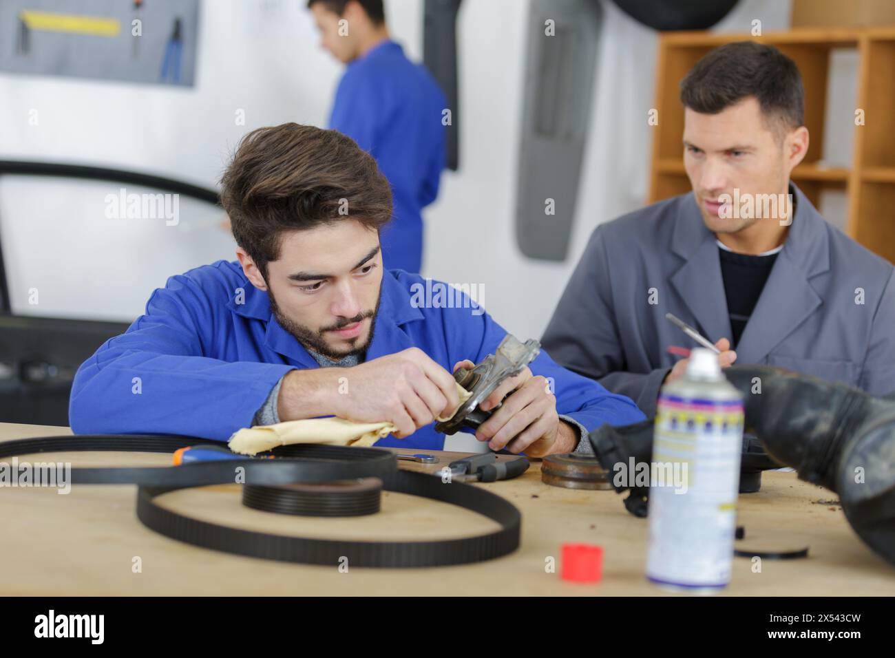 instructor with student in repairshop changing motor oil Stock Photo