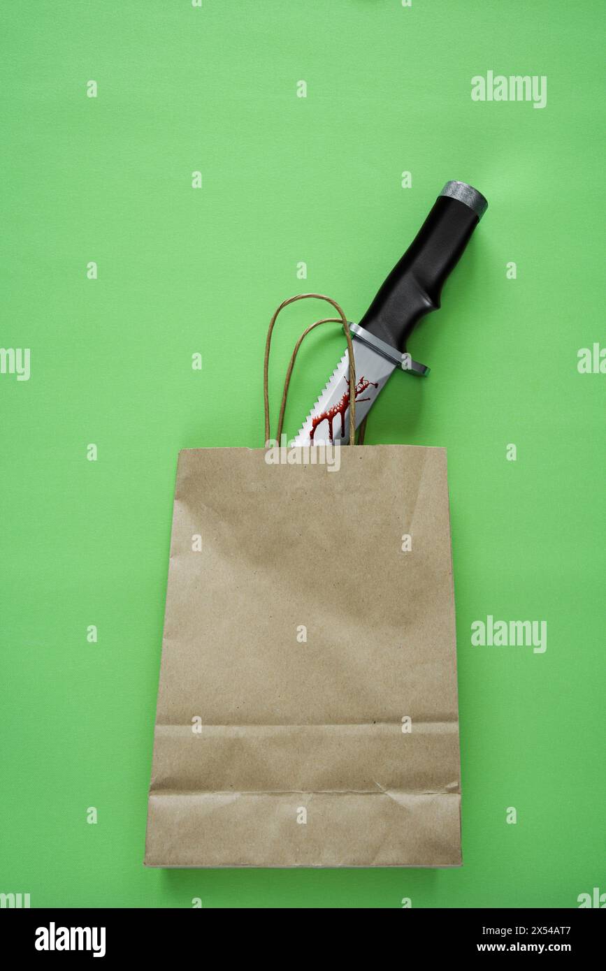 Bloody hunting knife in a brown paper bag. Stock Photo